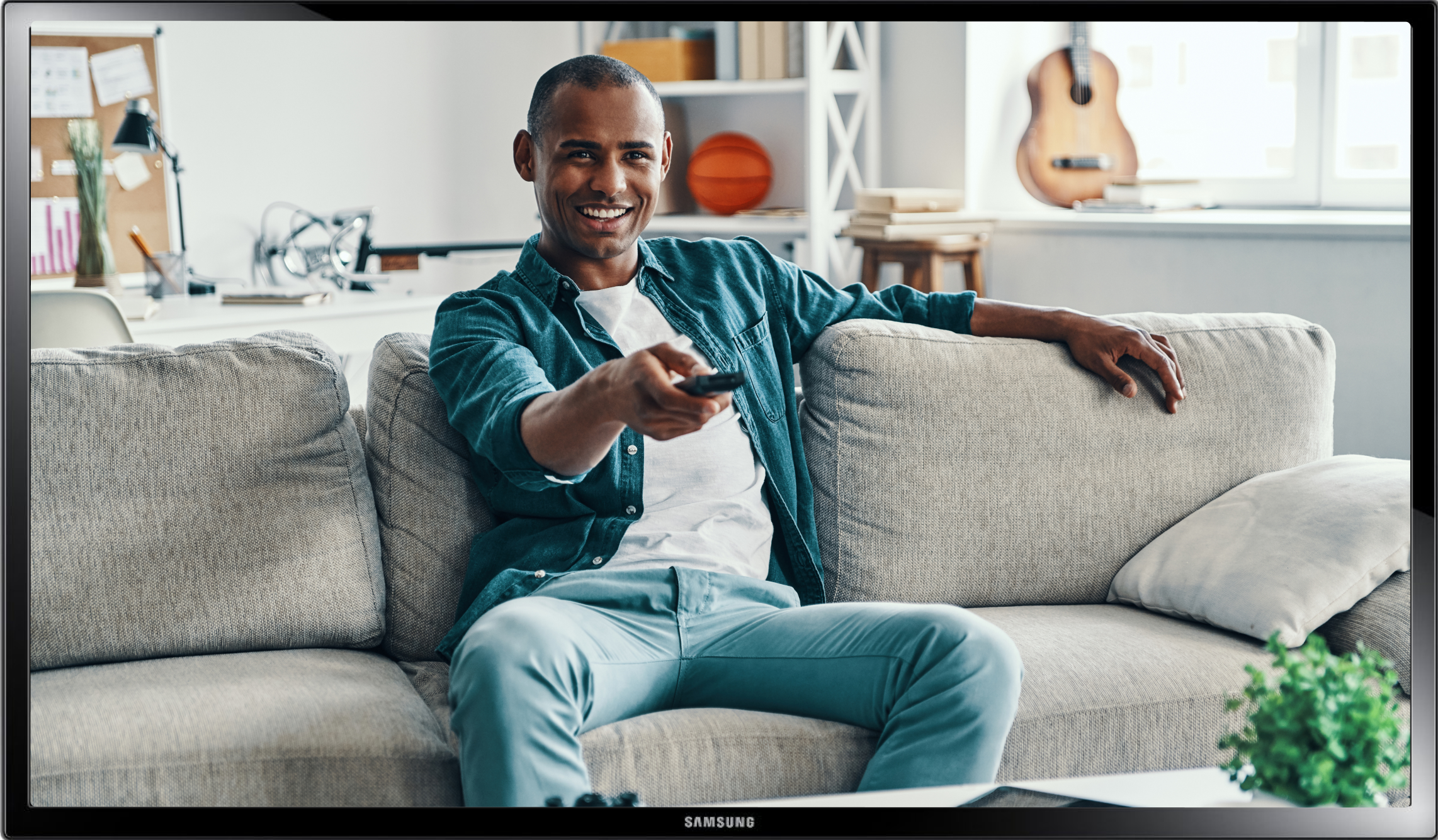 a man smiling and holding remote controller